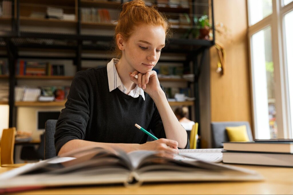 aluna fazendo anotações no caderno depois de saber como estudar para o vestibular