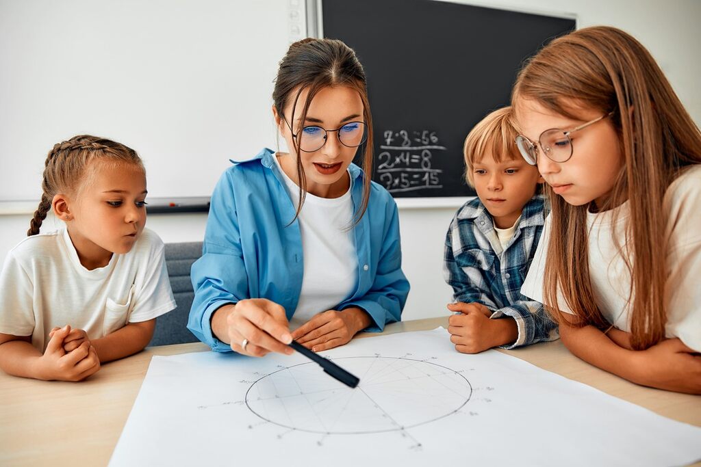 Professora ensinando matemática financeira para crianças em sala de aula