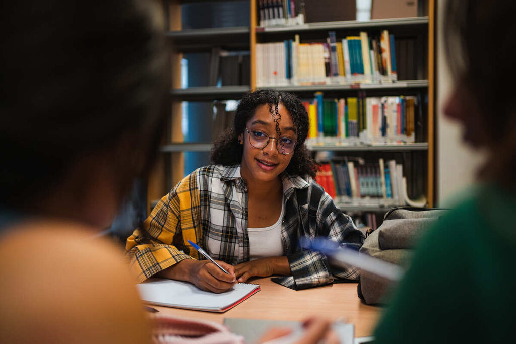 Alunos em biblioteca estudando os verbos defectivos