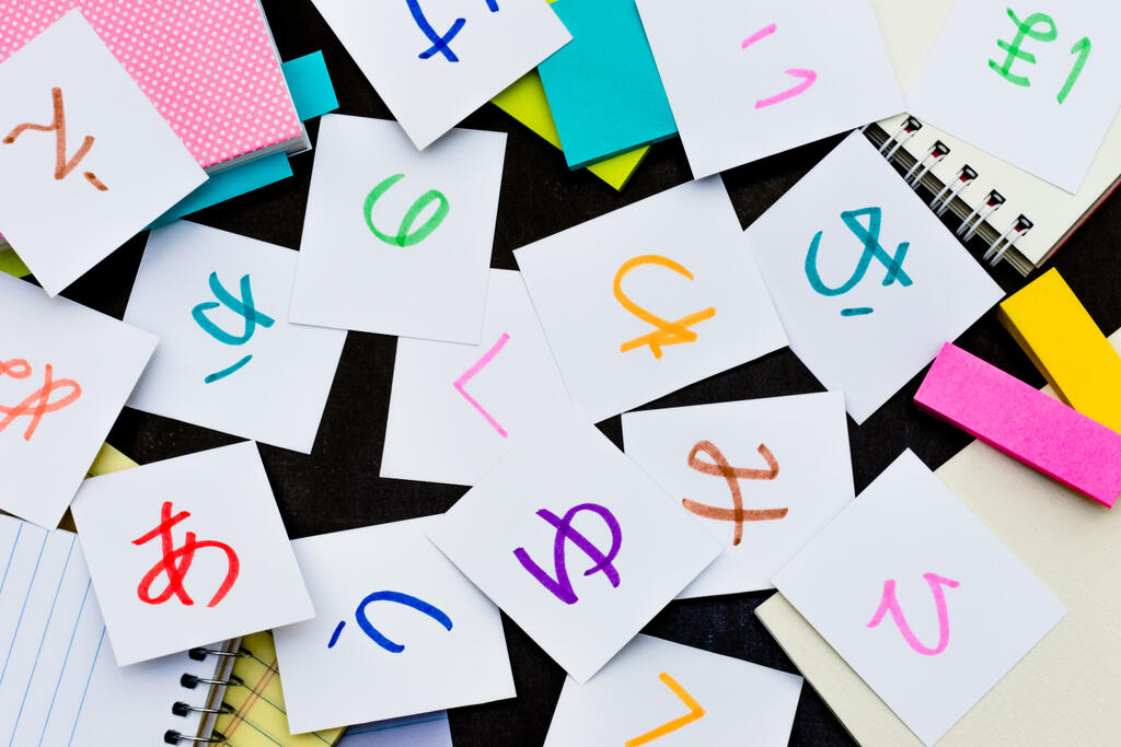 Pequenos papéis com kanjis japoneses escritos com canetas coloridas.