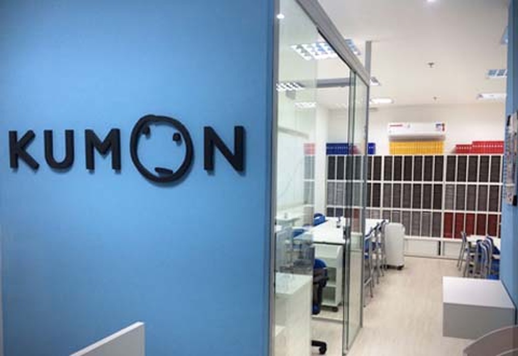 Logo do Kumon em parede dentro de sala de aula.