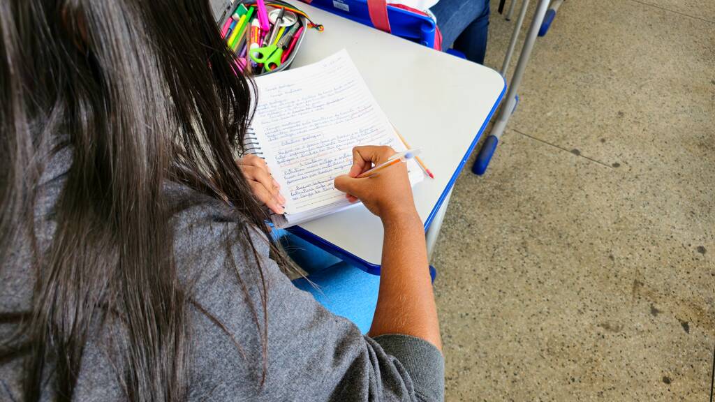 Menina estudando exemplos de adjunto adnominal.