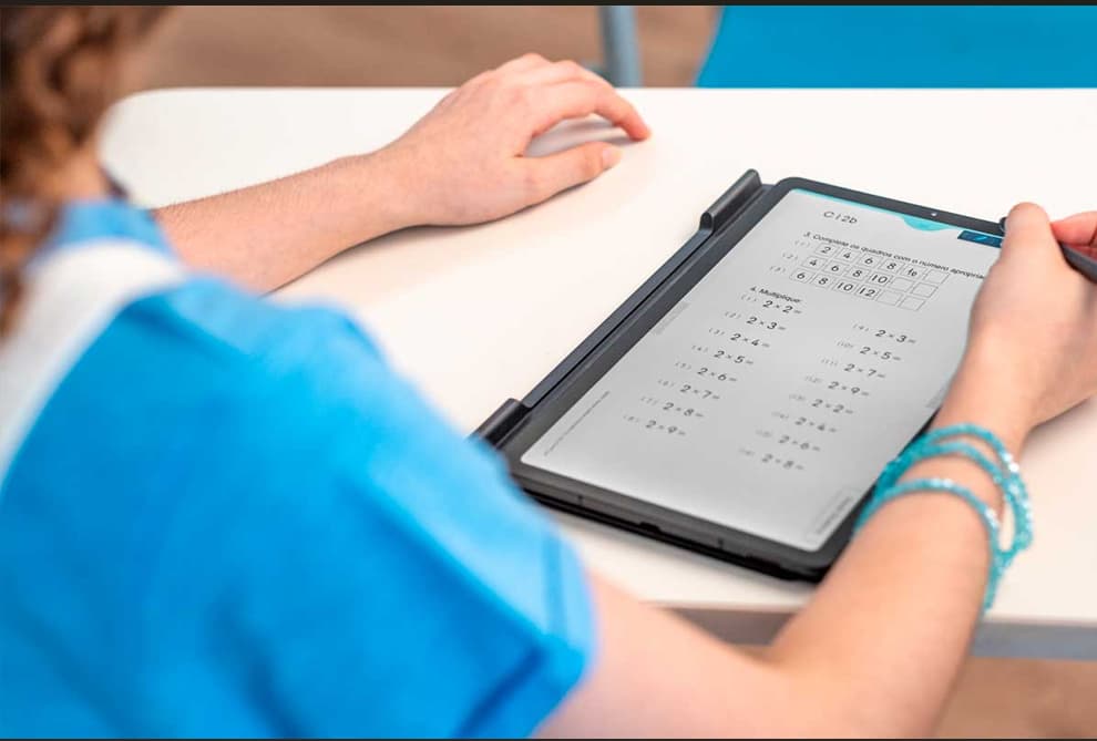Aluna utilizando tablet para acessar o material Kumon.