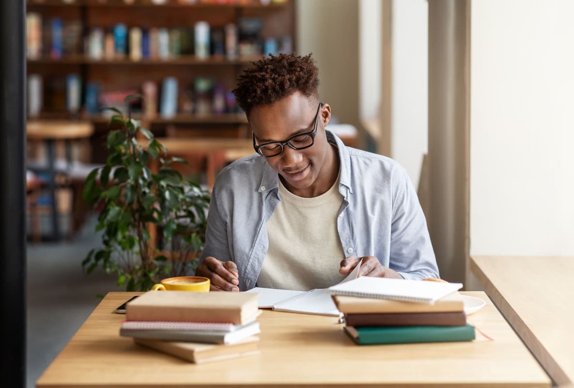 Homem estudando e escrevendo em um caderno