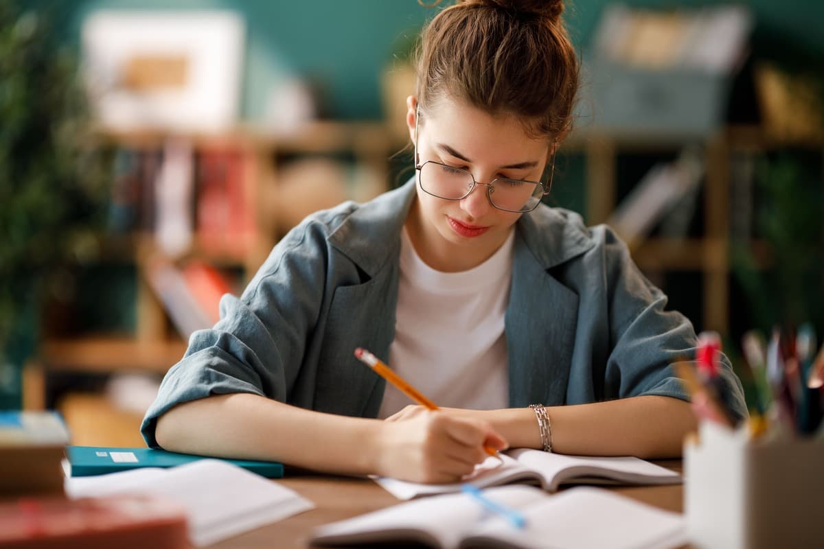 Pessoa escrevendo em um caderno durante os estudos