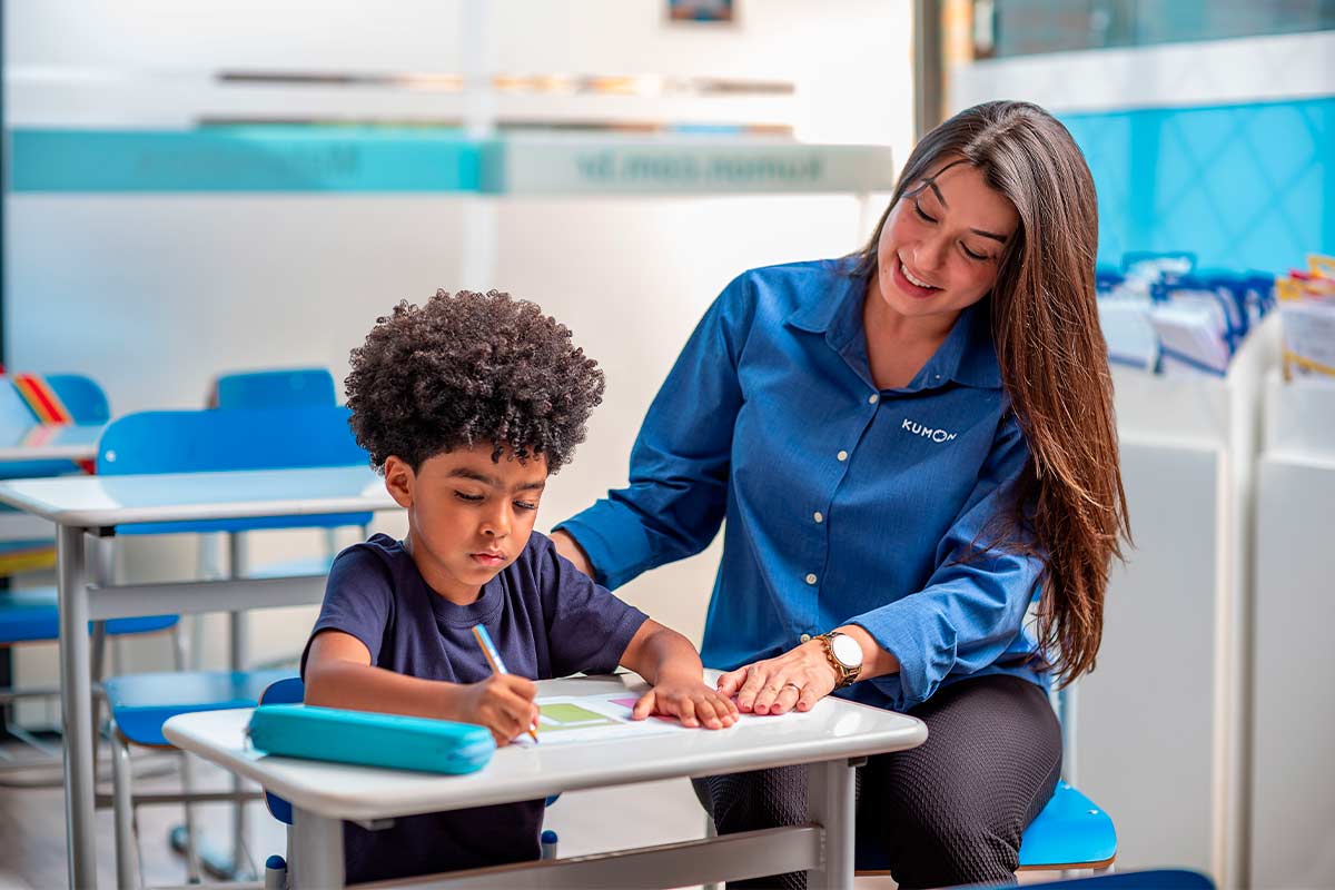 Orientadora com aluno pré-escolar estudando 